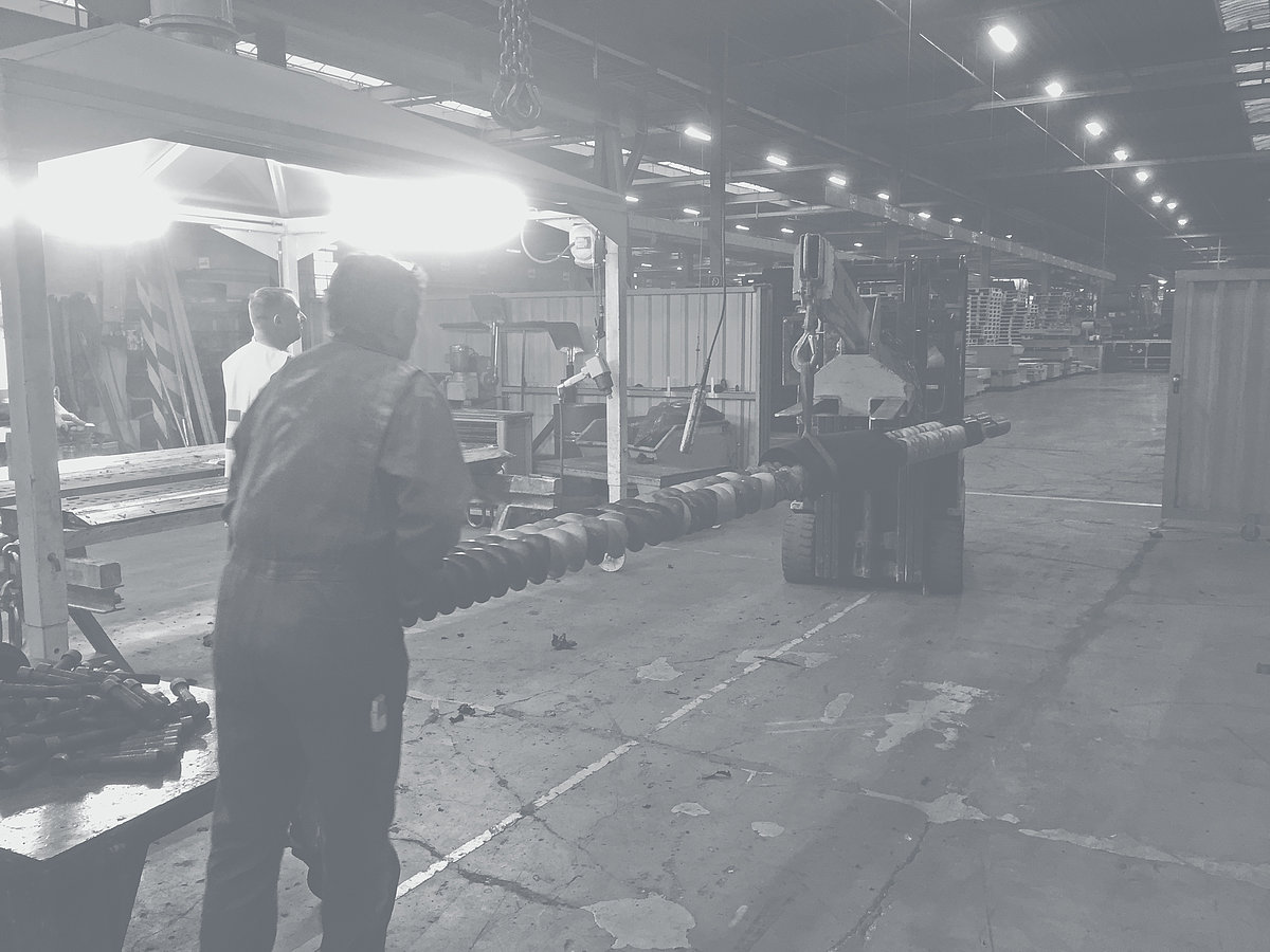 Carretillas elevadoras transportando husillos portantes con los segmentos en una nave de la fábrica.