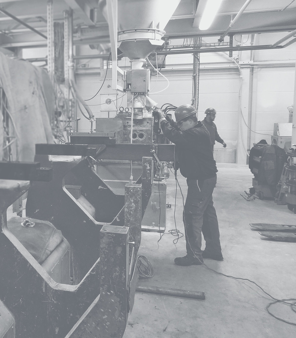 Der Service von Extruder Experts begleitet seine Kunden auf der gesamten Prozesskette. Mitarbeiter in einer Werkstatt bedient eine Maschine